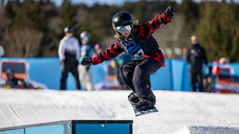 Snowboarder makes a jump off a box