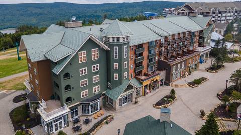 Exterior view of Highland House vacation rentals located above shops and restaurants at Snowshoe Mountain Resort 