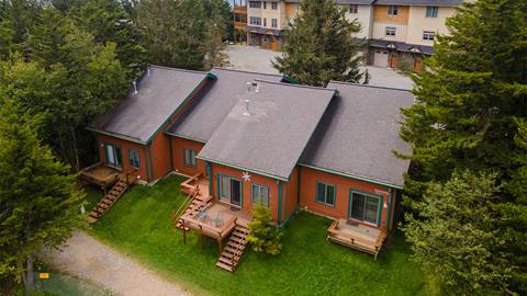 Aerial view of Powder Monkey vacation rentals at Snowshoe Mountain, showing cozy townhomes with private decks, surrounded by trees near the lift