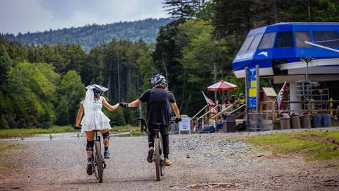 Bride and groom mountain bikers fist bump | Snowshoe Mountain