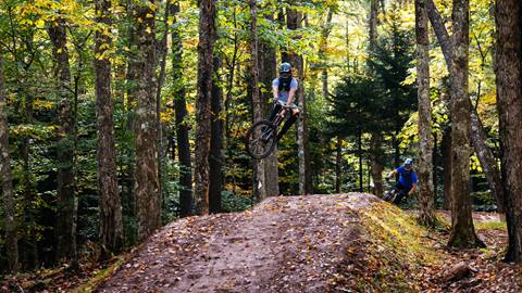 Mountain bikers hitting jump at Snowshoe Bike Park