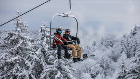 Snowboarders on lift at Snowshoe Mountain