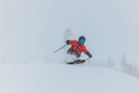 Skier carving through deep powder