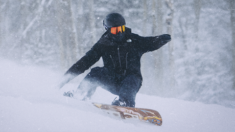 Snowboarder going through lots of powder at Snowshoe Mountain